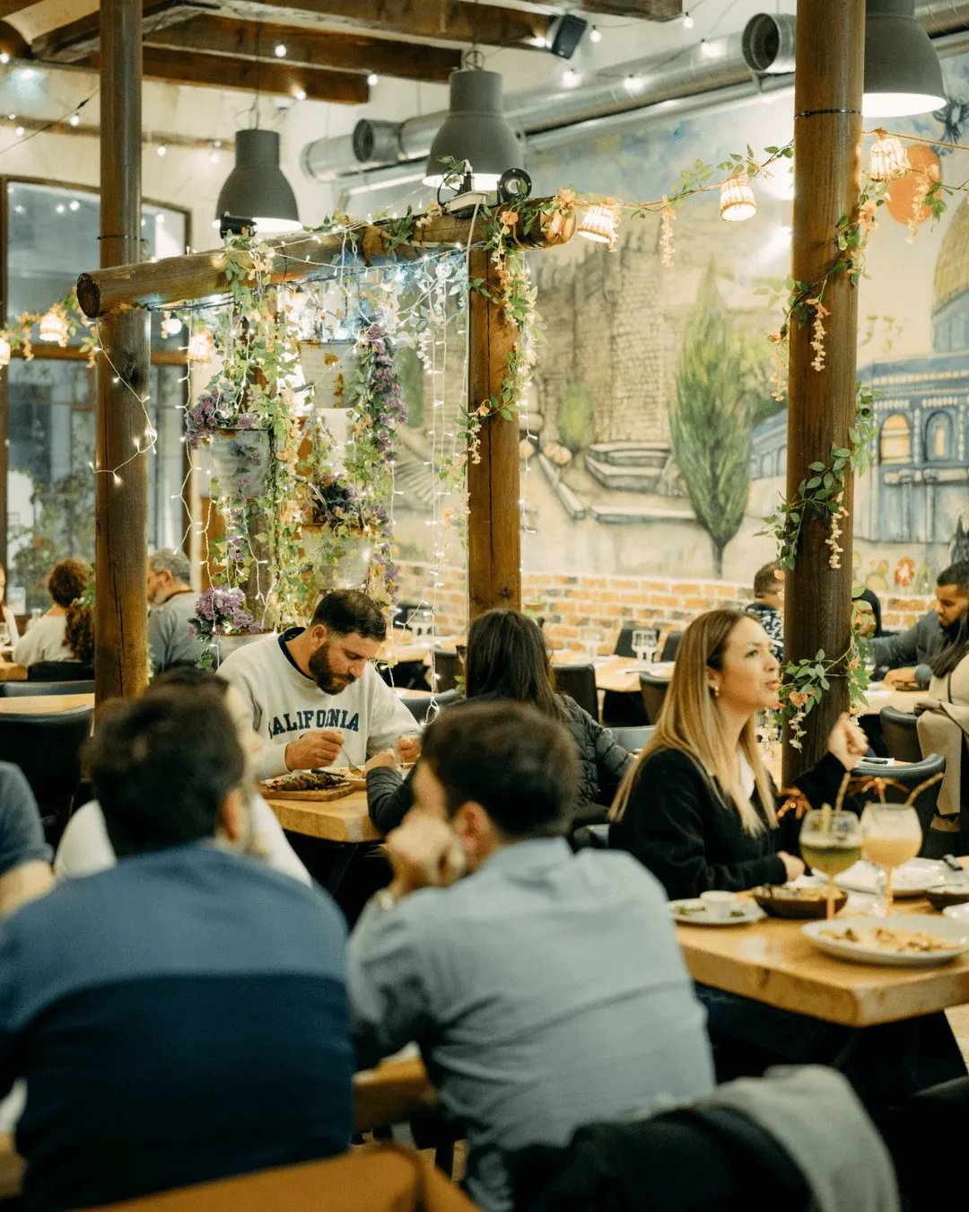 Intérieur chaleureux du restaurant La Palestine avec fresque de Jérusalem